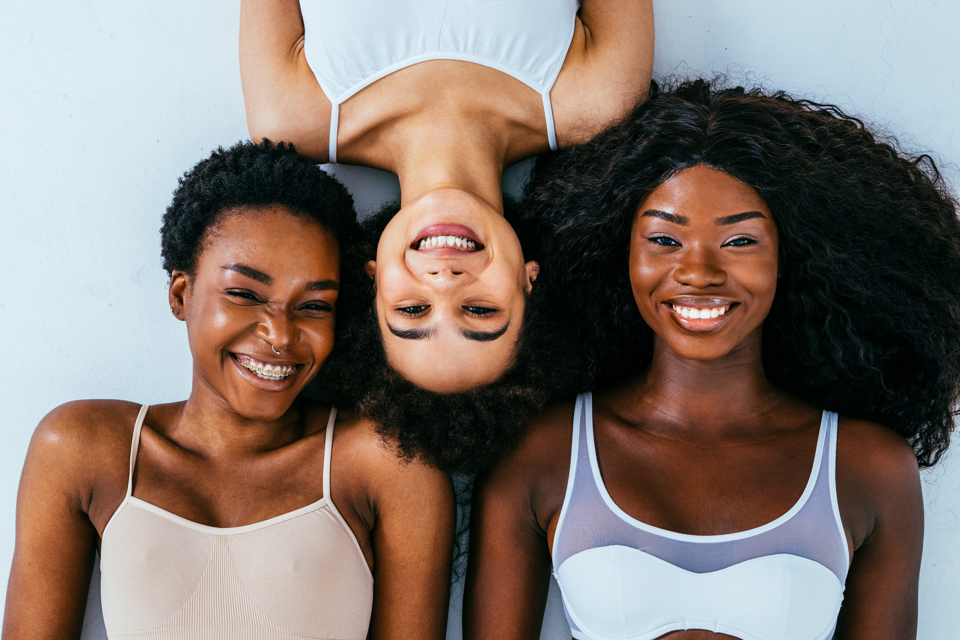 Women Lying on a Plain Background 